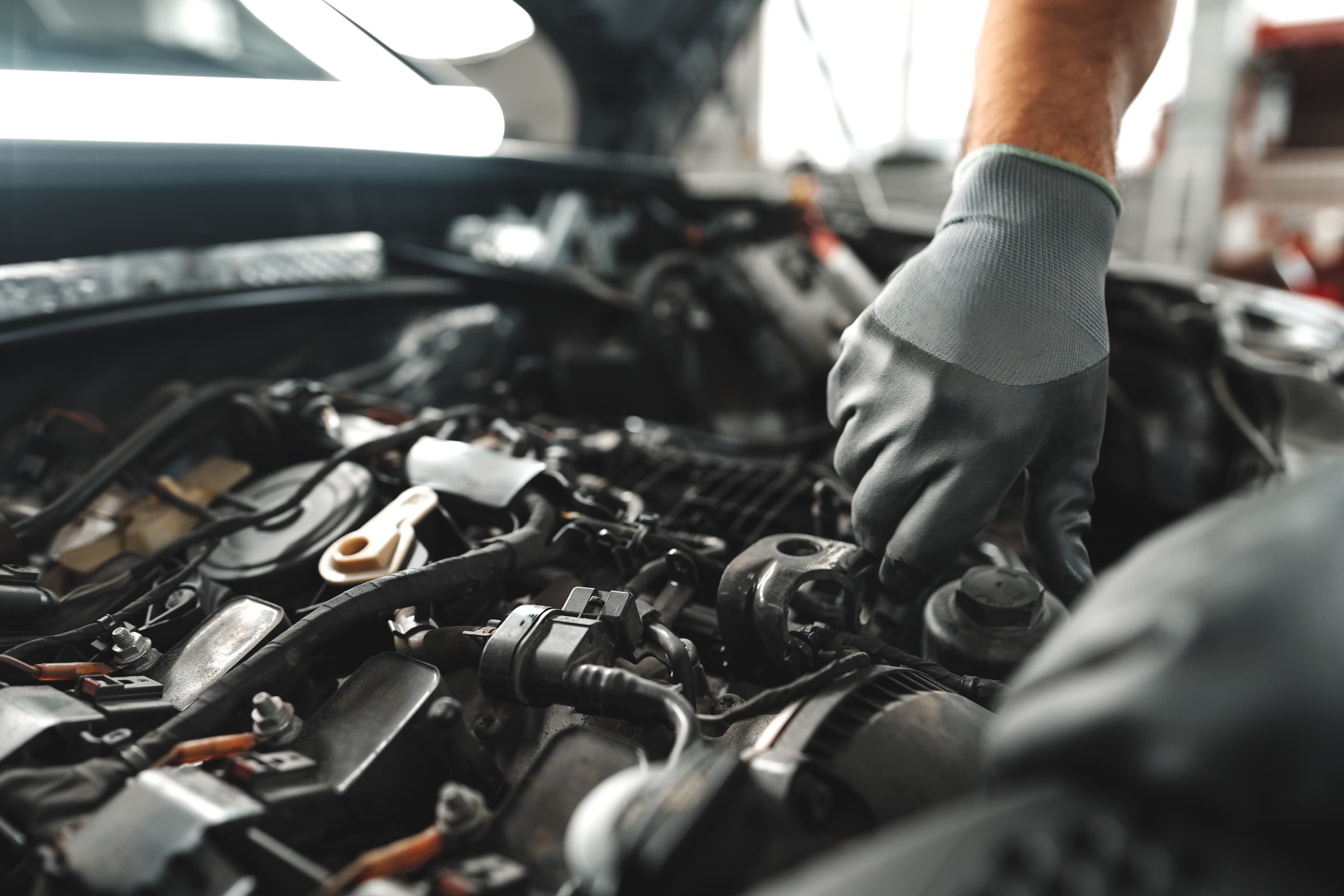 Mechanic performing maintenance on a vehicle engine.